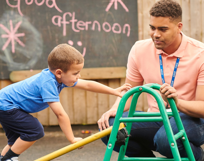 Adult helping child climb on obstacle course