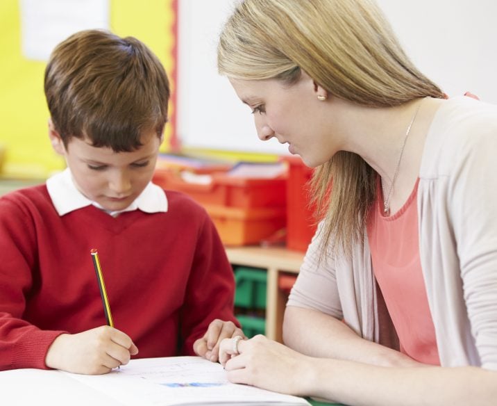 Child and teacher working at desk