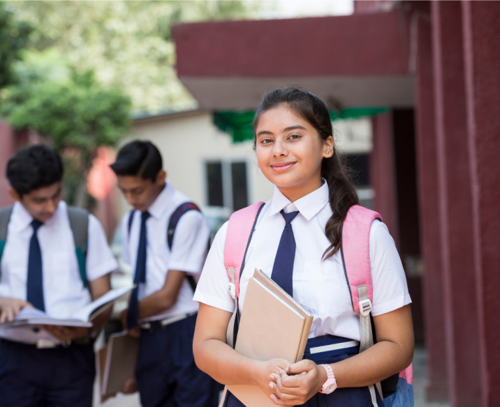 High school student holding books and smiling