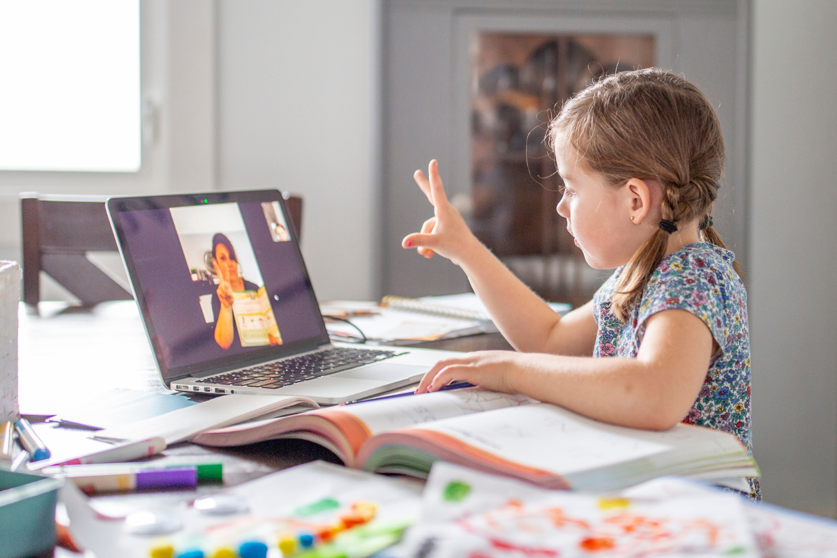 Young girl doing online maths tutoring session on laptop