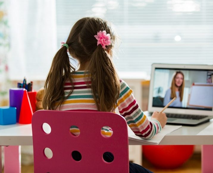 Child participating in online session on laptop