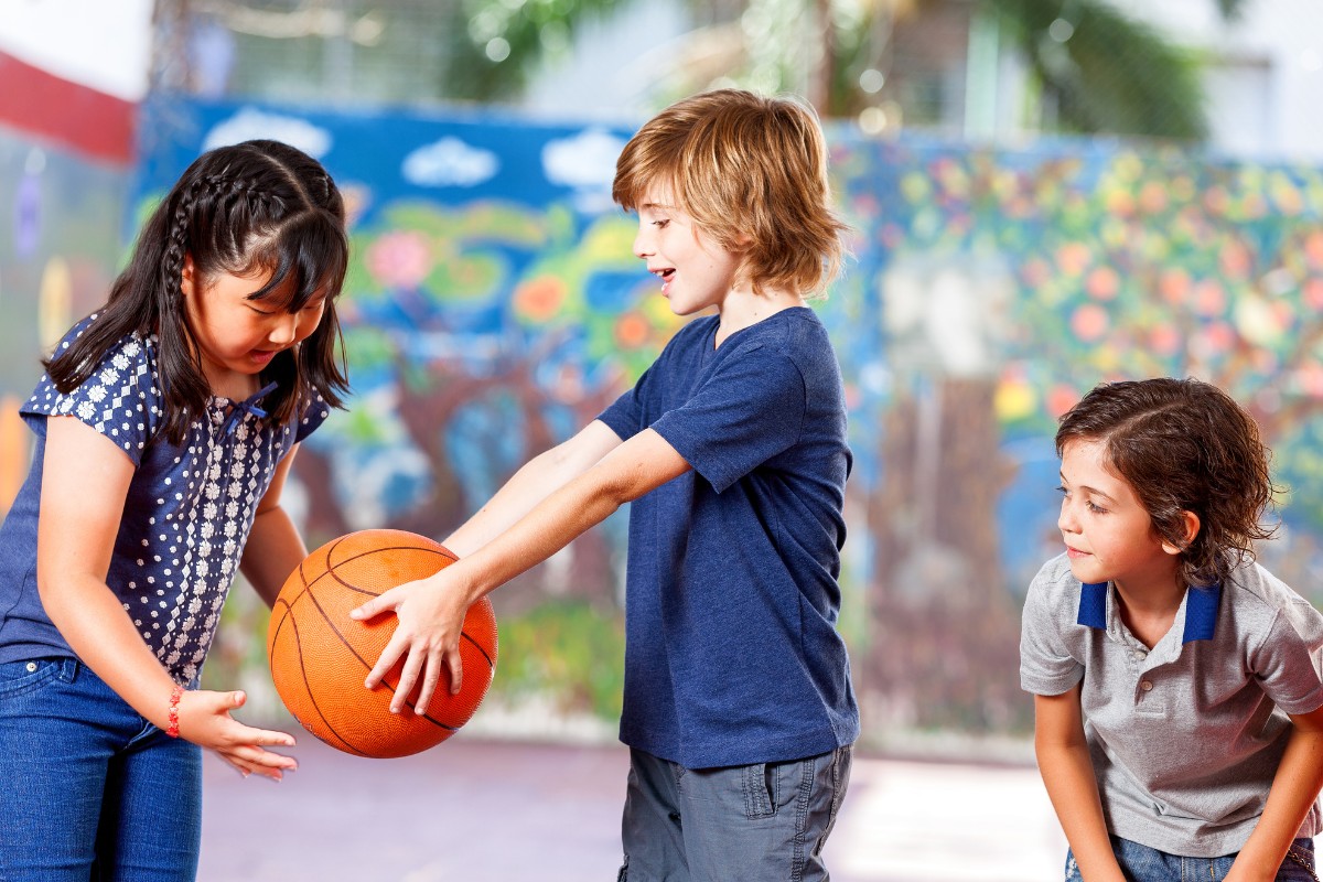 Boy handing girl basketball to play together