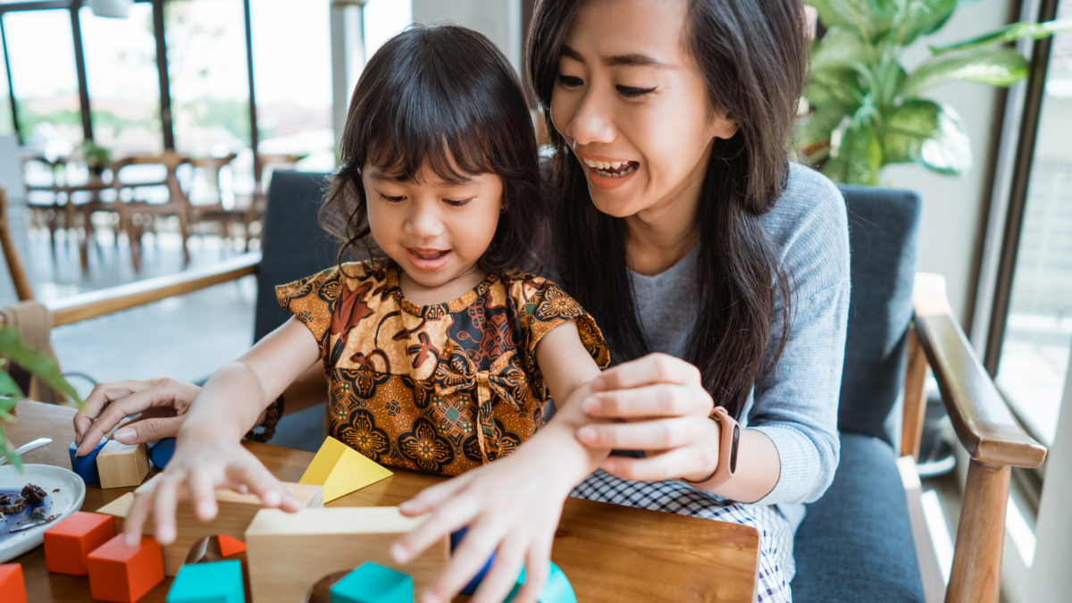 Mother playing with daughter at table