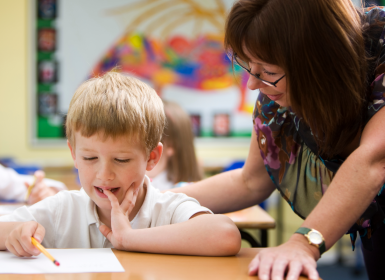 Teacher working with student in classroom