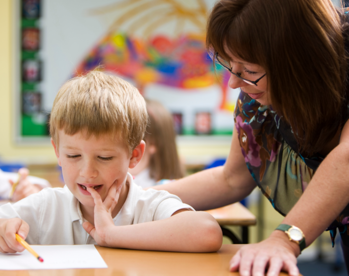 Teacher working with student in classroom