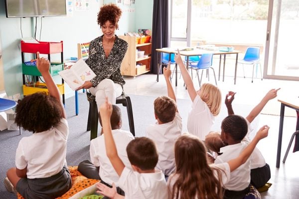 Teacher in classroom answering students' questions