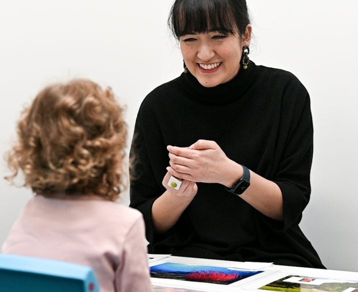 Speech pathologist playing game with young girl at table