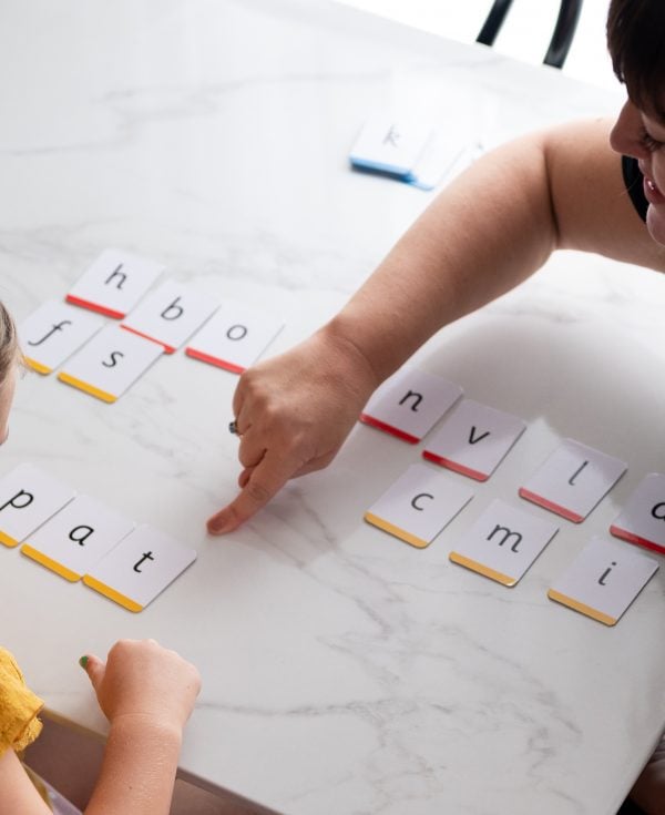 Teacher working with student to make words with letter cards