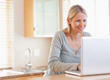 Mum sitting at table looking at laptop