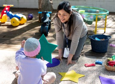 Learning Links early childhood educator playing outside with young child