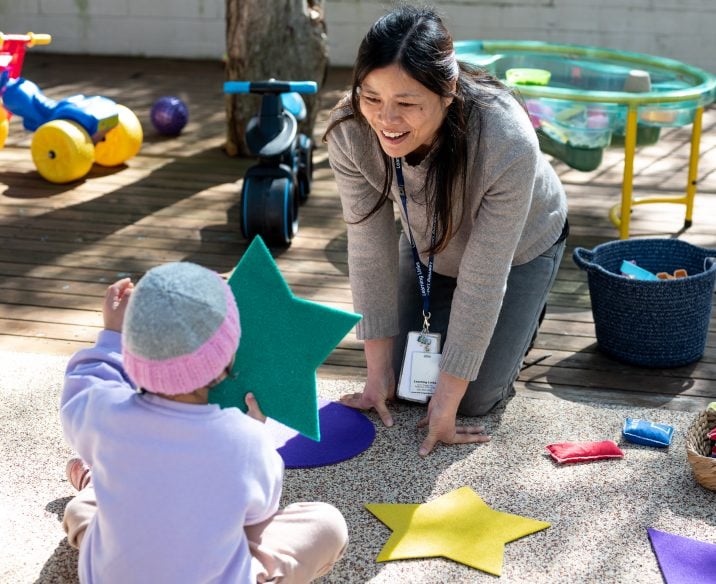 Learning Links early childhood educator playing outside with young child