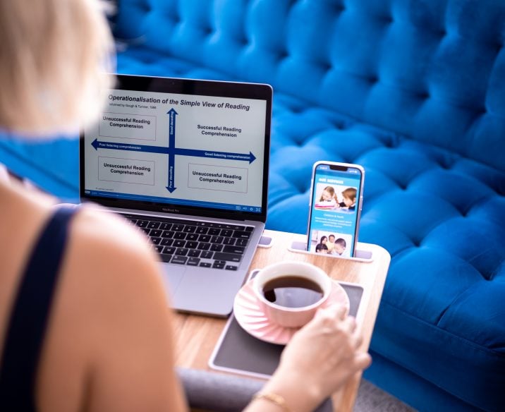 Woman sitting in living room watching online course on iPad