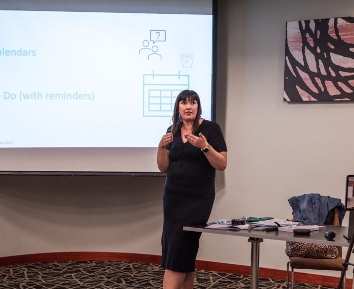 Presenter speaking in front of large screen