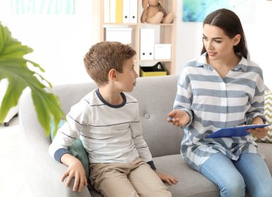 Psychologist and child sitting on couch talking