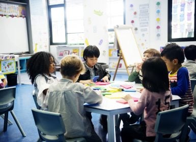 Small children sitting around table in group doing activity