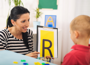 Young boy learning 'r' sound with speech pathologist