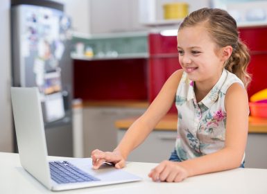 Young girl sitting in front of laptop at home