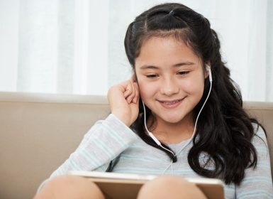 Teenage girl having conversation using iPad and earphones