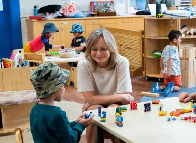 Learning Links staff members sitting in Preschool with child