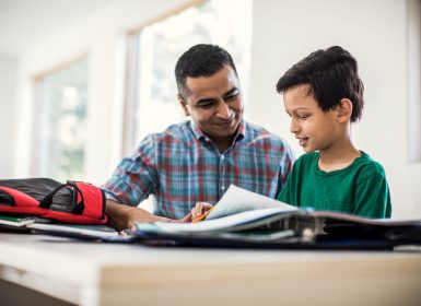 Father and son doing homework at home