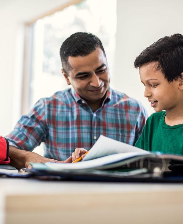 Father and son doing homework at home