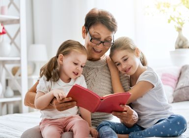 Grandmother reading to granddaughters