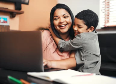 Mother and child in front of laptop screen