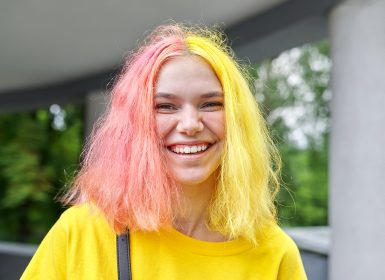 Portrait of a happy laughing teenage girl with coloured dyed hair