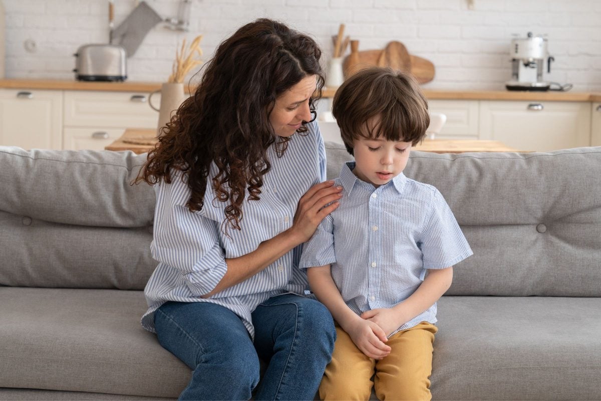 Mother with arm around child comforting them to help them regulate their emotions