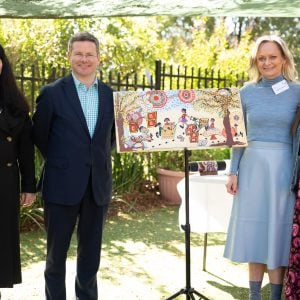 Dr Lana Leslie, Hon David Coleman MP, CEO Birgitte Maibom and RAP designer Amy Allerton standing with RAP artwork commissioned by Aunty Deanna Schreiber