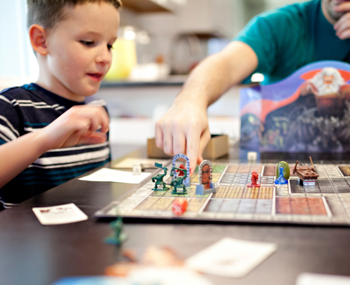 Child and adult playing tabletop role play board game