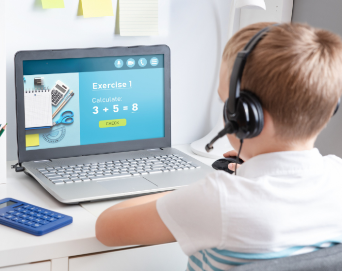 Boy wearing headset looking at laptop screen that displays a maths problem