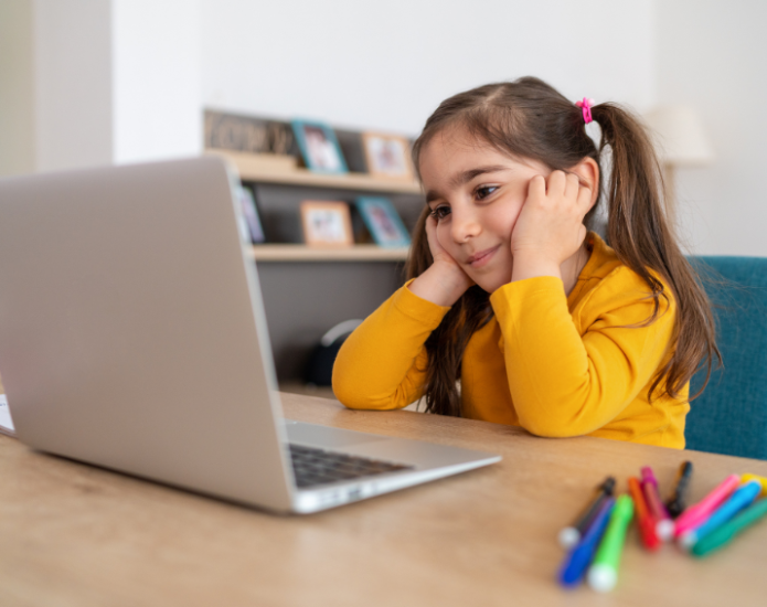 Young girl with pigtails looking at laptop screen