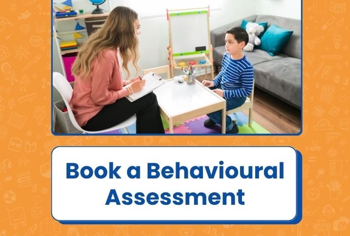 Psychologist sitting at small table with a child and holding a clipboard